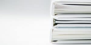 Foto de uma pilha de documentos, simbolizando a lista mestra e a gestão de documentos.