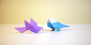 Imagem de dois origamis coloridos representando o post sobre como conscientizar os colaboradores.