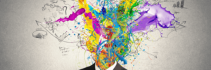 Imagem de um homem de terno e gravata preto e no lugar da sua cabeça, tem um monte de tintas simbolizando o artigo sobre implantar-uma-norma-iso-de-inovacao