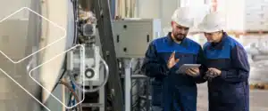 Dois trabalhadores utilizando equipamentos de proteção individual em ambiente industrial durante atividades operacionais.