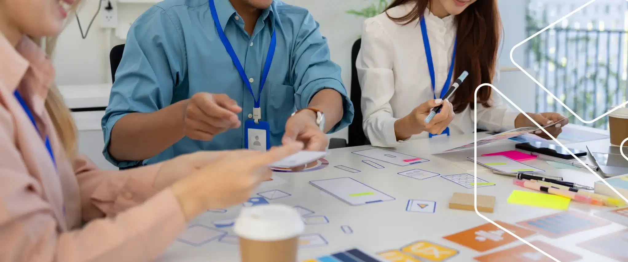 Equipe reunida em volta de uma mesa com cartões, post-its e canetas, trocando ideias